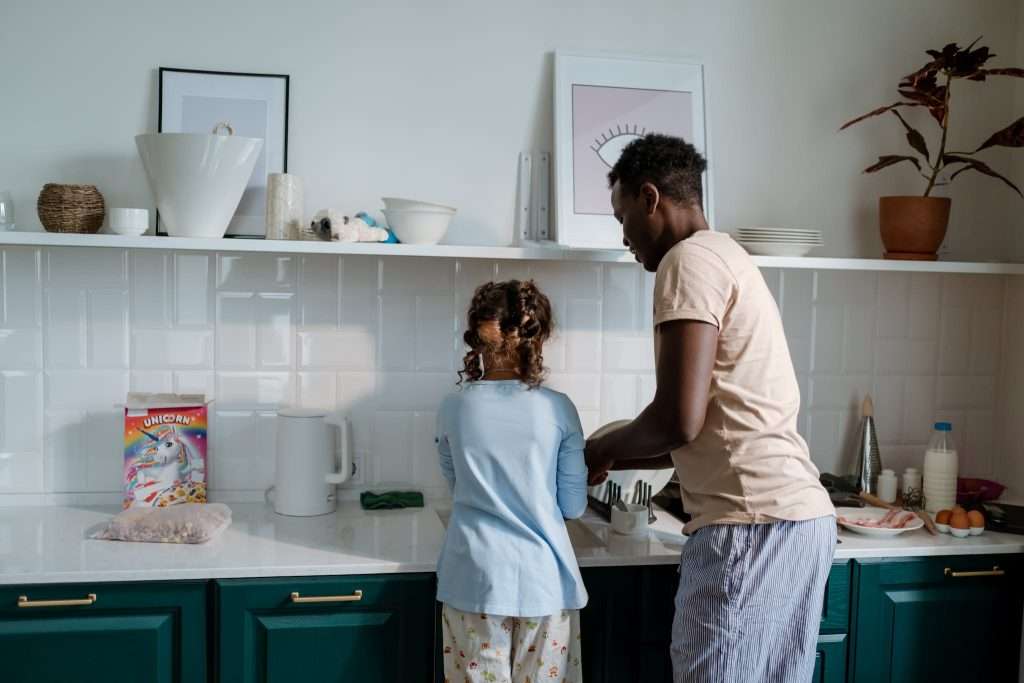 Girl and Man Standing beside Kitchen Counter Top 